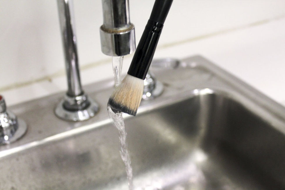 Rinse the bristles under water. "Make sure you don't get water above the handle of the brush," warns Laramie. "This will loosen the glue over time." In this instance, I'm washing a face brush: Phuse Beauty Powder to the People Brush ($13, Phuse).
