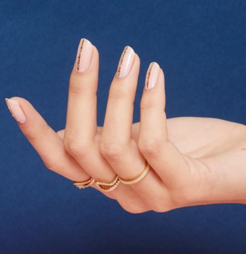 Sometimes the simplest geometric designs are all you need to make a bold statement. This gorgeous manicure features a nude-pink base and single strip of gold on each nail, which will coordinate beautifully with gold or rose gold jewelry.
See more at Paintbox Nails »
