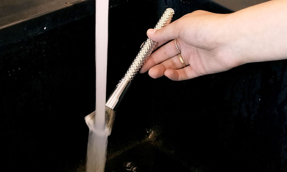 Rinse the bristles under water. Avoid getting water above the handle of the brush, which can loosen the glue over time. The brush we're washing is Moda Metallics Buffer brush ($9, beautyusa.royalbrush.com).
