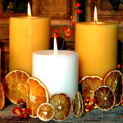 Warm up your holiday table with a scentsational centerpiece — dress pillar candles with dried oranges, lemons, and limes. Using a glue gun, connect the citrus slices to each other, forming a band around the base of each candle. 