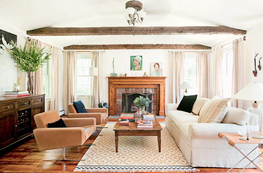 The antique wooden beams are a welcome contrast to the modern furniture in an airy farmhouse. 