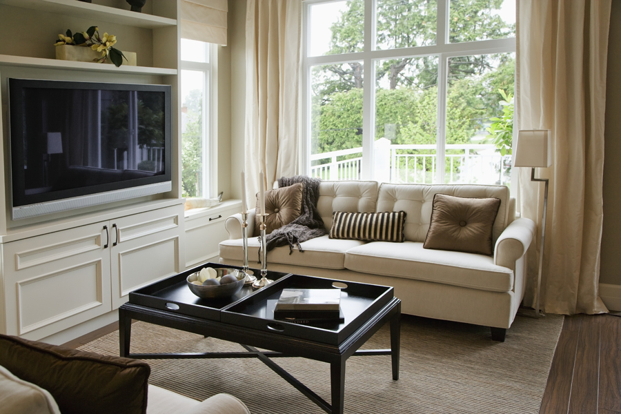 Position your couch under an oversized window to allow the sunlight and outdoor scene be the focal point of an otherwise neutral room. 