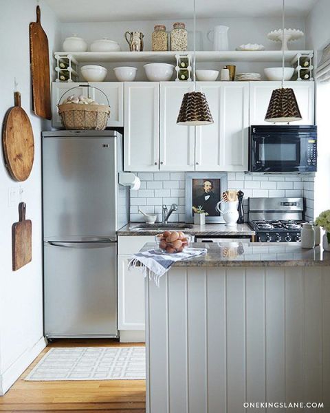 If your cabinets are too cramped to fit all of your kitchen gear, stealthily use the cuter items as decor. For instance, chunky vintage cutting boards or bright colanders can double as artwork. And a row of matching mixing bowls stuck above cabinets looks intentional, not messy. See more at One Kings Lane » 